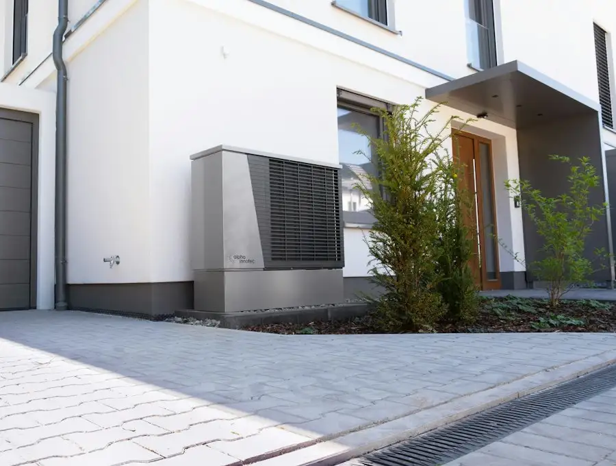 Wärmepumpe vor einem modernen Einfamilienhaus