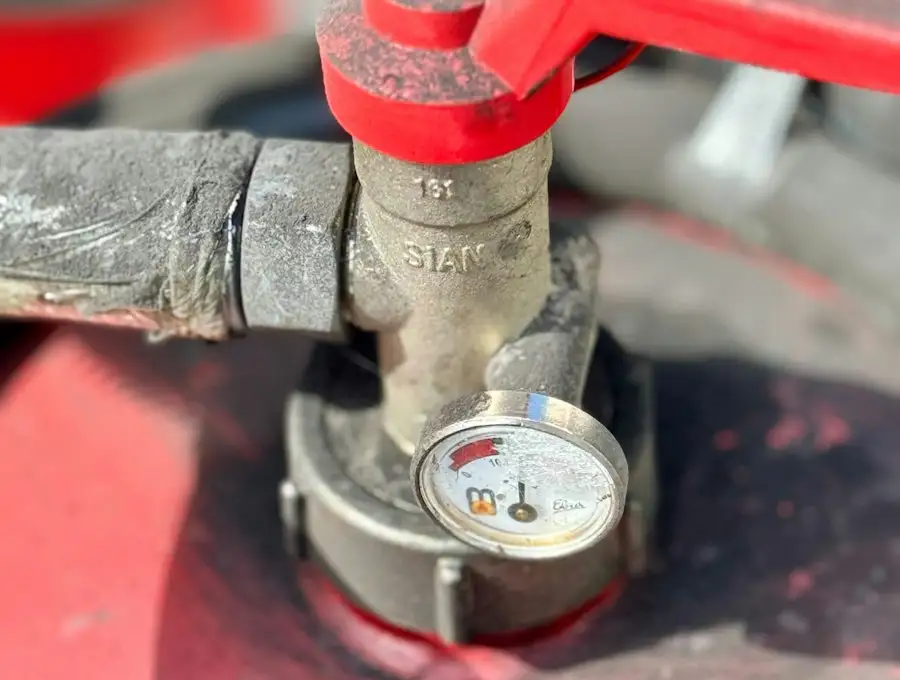 Rotes Ventil mit Manometer an einer Heizungsleitung