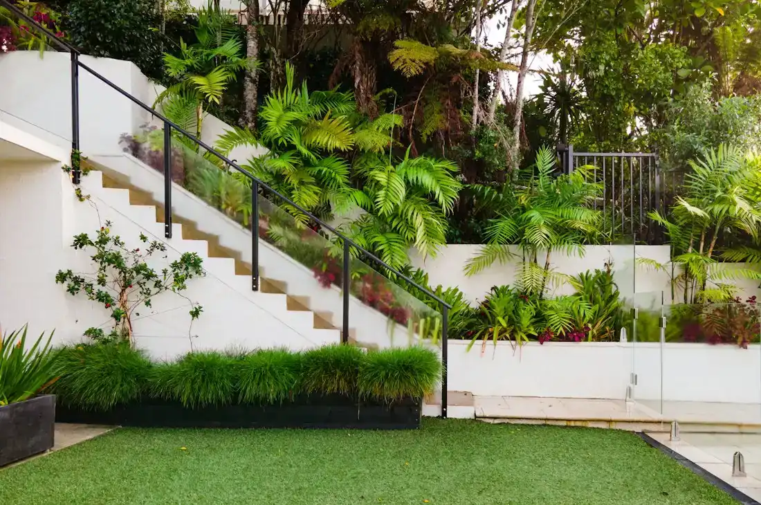 Moderner Garten mit weißen Mauern, Treppe und Rasen