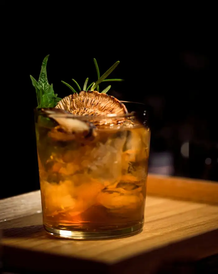 Cocktail im Tumbler mit Rosmarin und getrockneter Orangenscheibe
