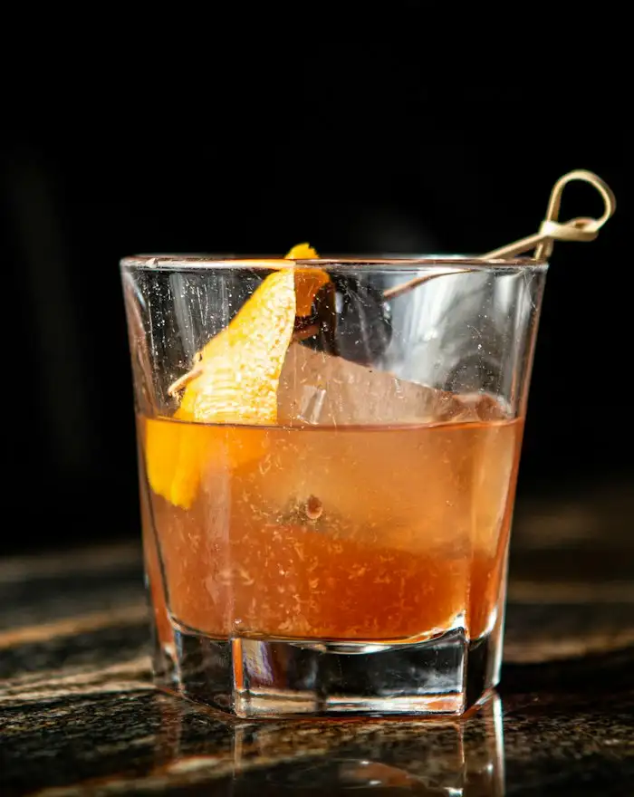 Old Fashioned mit großem Eiswürfel und Orangenzeste