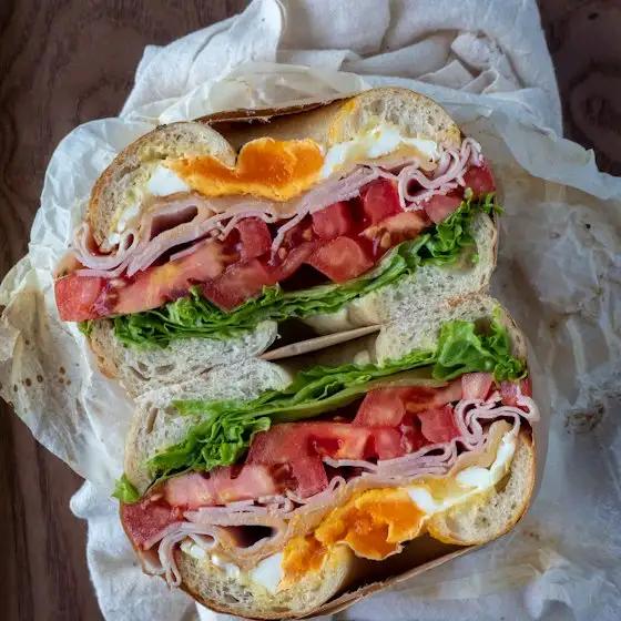 Bagel mit Schinken, Ei, Tomate und Salat